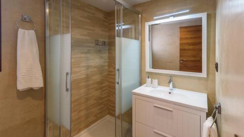 a bathroom with a shower and a sink and a mirror at Villa Cinco Soles Árchez by Ruralidays in Árchez