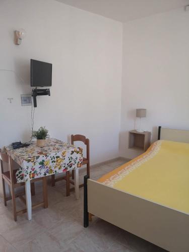 una camera con tavolo, letto e TV di Torre d'Oriente a Rodi Garganico