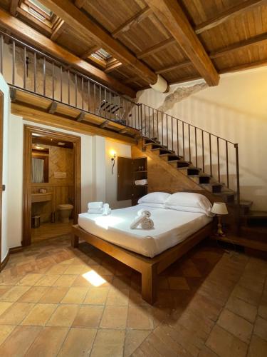a bedroom with a large bed and a staircase at Al Palazzetto in Tivoli