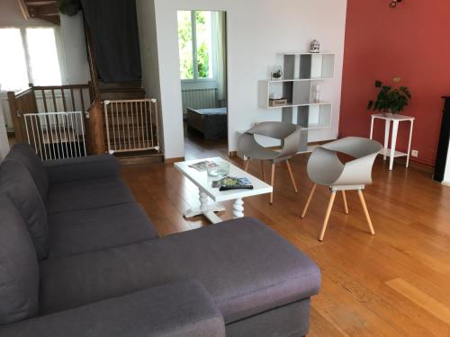 a living room with a couch and a table at Agréable maison de bourg aux portes de TOURS in Semblançay