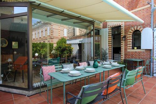 a green table and chairs on a patio at Evasion in Albi