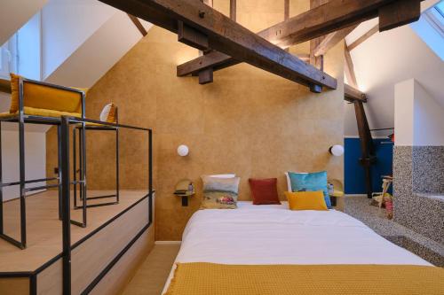 una camera da letto con un grande letto con cuscini colorati di Domaine de Ronchinne - Insolites a Maillen