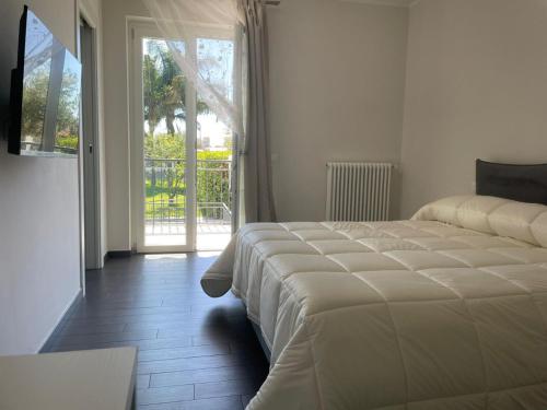 ein Schlafzimmer mit einem großen Bett und einer Glasschiebetür in der Unterkunft Villa Marisa Resort in Castellammare di Stabia