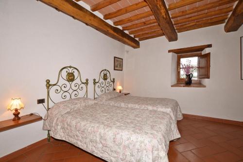 阿爾奇多索的住宿－Villa La Chiesina，一间带一张床的卧室,位于带木制天花板的房间内