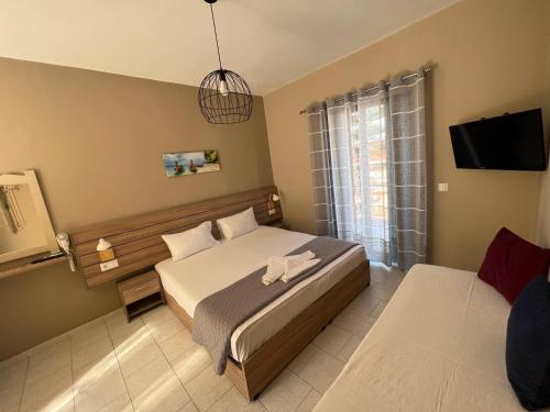 a bedroom with a bed and a television in it at Ilaeira rooms in Argasi
