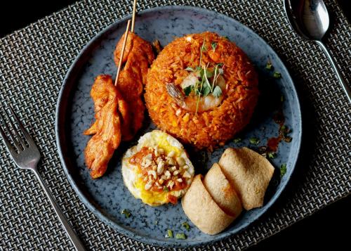 a plate of food with fish and rice and bread at Radisson Resort and Spa Lonavala in Lonavala