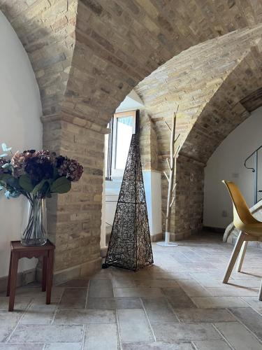 a room with a stone wall and a vase of flowers at ANPEMO Casa Vacanze dimora storica dal 1837 in Silvi Paese
