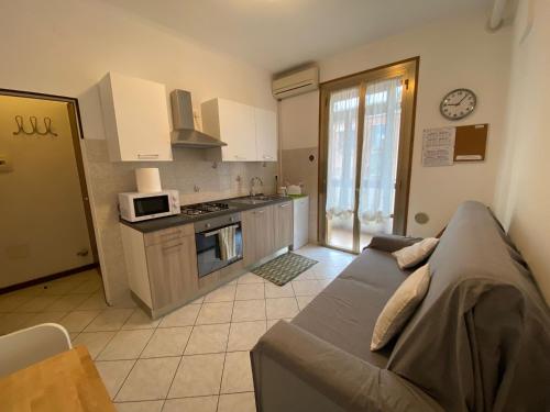 Il comprend un salon avec un canapé et une cuisine. dans l'établissement Little and cozy flat near Venice, à Marghera