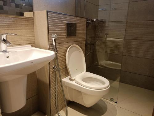 a bathroom with a toilet and a sink and a shower at Retrieve Health & Wellness in Cochin