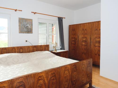 Un dormitorio con una gran cama de madera y una ventana en Holiday Apartment Nana, en Reichenfels