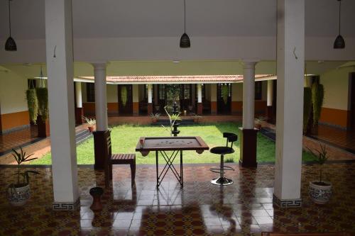 a courtyard with a table and chairs in a building at 3 Hills Hostel in Wayanad