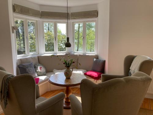 a living room with a table and chairs and windows at Ferienhaus Leezen in Leezen
