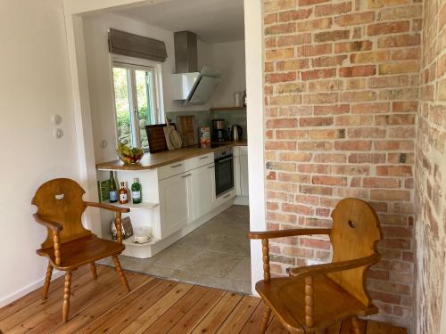 a kitchen with two chairs and a brick wall at Ferienhaus Leezen in Leezen