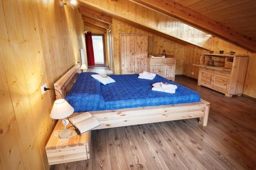 una camera con un letto in una cabina di legno di La Marmote Albergo Diffuso di Paluzza San Nicolò a Paluzza