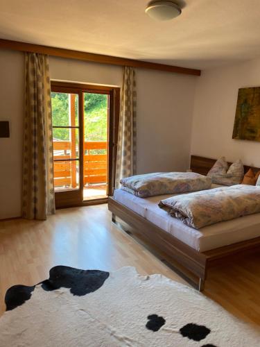 a bedroom with two beds and a rug on the floor at Schneiderhaus in Bagni di Lavina Bianca