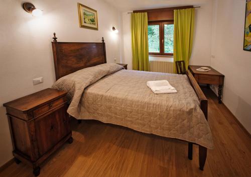 una camera con un grande letto con struttura in legno di La Marmote Albergo Diffuso di Paluzza Testeons Nord a Paluzza