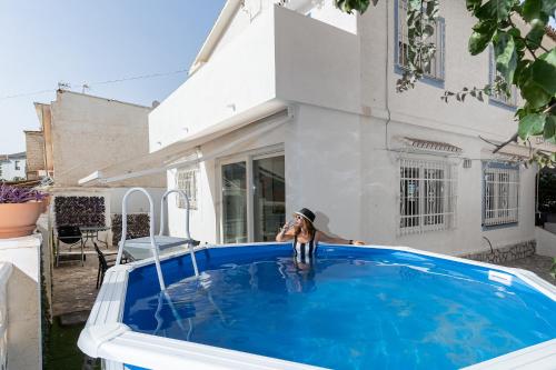 a dog standing on the side of a swimming pool at MONKÓ VILLA MIERES in Torremolinos