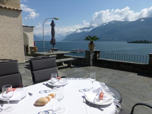 einen Tisch mit Blick auf das Wasser und die Berge in der Unterkunft Casa Chatelain in Ronco sopra Ascona