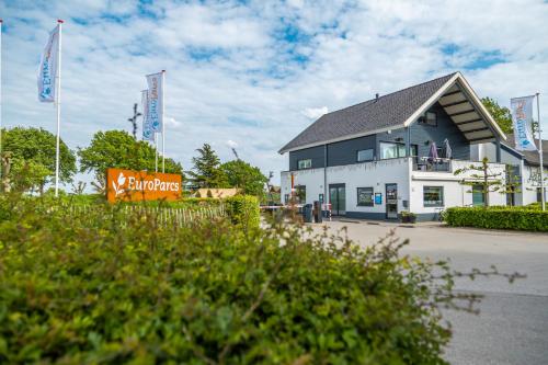 un edificio blanco con un cartel delante en EuroParcs Gulperberg, en Gulpen