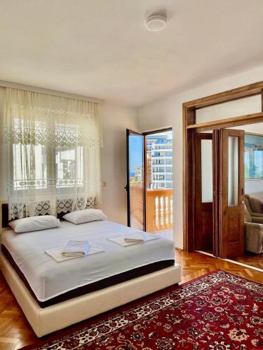 ein Schlafzimmer mit einem großen Bett und einem großen Fenster in der Unterkunft Adriatic Apartments in Ulcinj