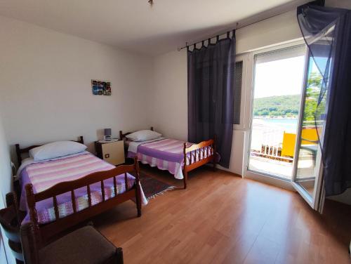 a bedroom with two beds and a large window at Apartmani David in Pula