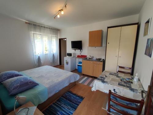 a small bedroom with a bed and a kitchen at Apartmani David in Pula