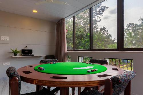 een tafeltennistafel in een kamer met een groene tafel bij Sunshine Bloom by StayVista - Your Oasis with Pool, Lawn, Gazebo, and Poker Table in Lonavala