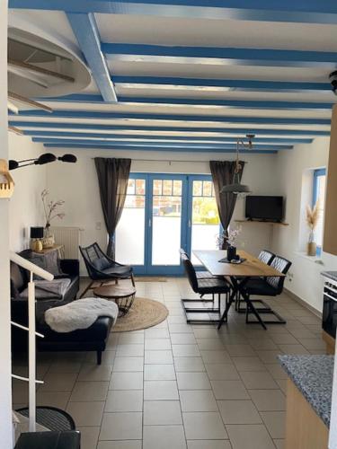sala de estar con techos azules, mesa y sillas en Ferienhaus am Yachthafen en Sellin