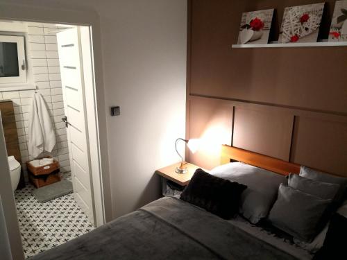 ein Schlafzimmer mit einem Bett und einer Lampe auf einem Tisch in der Unterkunft Apartmány RŮŽIČKA in Mikulov