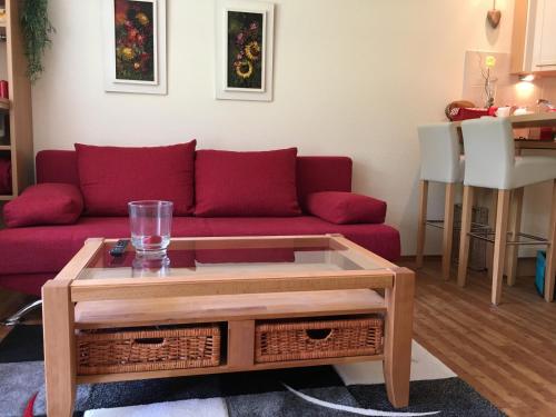 uma sala de estar com um sofá vermelho e uma mesa de centro em Apartment Kleeblatt em Hahnenklee-Bockswiese