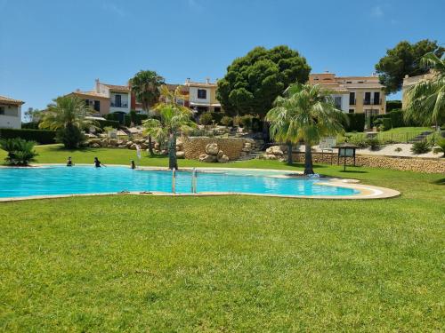 una piscina en un parque con palmeras en Casablanca, House Near Benidorm, en Finestrat