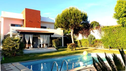 a house with a swimming pool in front of a house at VILLA DA FONTE - BY MECO in Alfarim