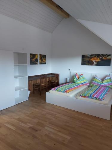 good bed Deitingen في Deitingen: غرفة بيضاء بسريرين وطاولة
