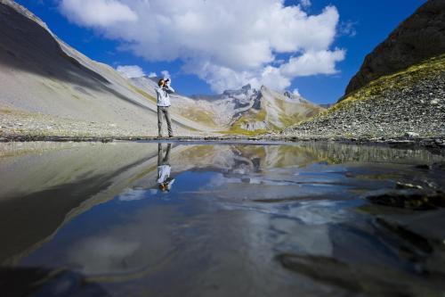 a person standing on a bridge over a body of water at Guarda Golf Hotel & Residences in Crans-Montana