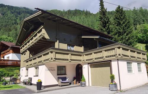 a large house with a porch and a garage at Landhaus Ostermann in Umhausen