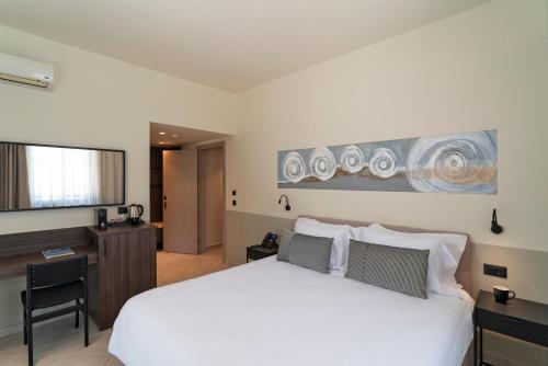 1 dormitorio con cama blanca y escritorio en Mariette Rhodes Urban Suites, en Rodas