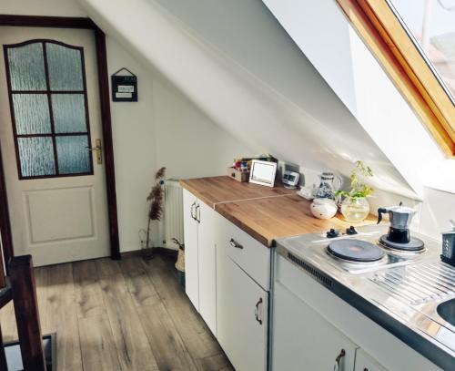 a kitchen with white cabinets and a counter top at MM Apartman in Badacsonyörs