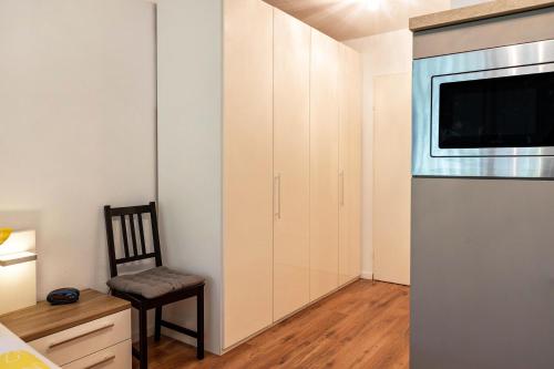 a living room with a chair and a microwave at Ferienwohnung Fetscher 2 in Reichenau