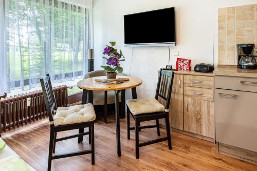 a kitchen with a table and chairs and a tv at Ferienwohnung Fetscher 1 in Reichenau