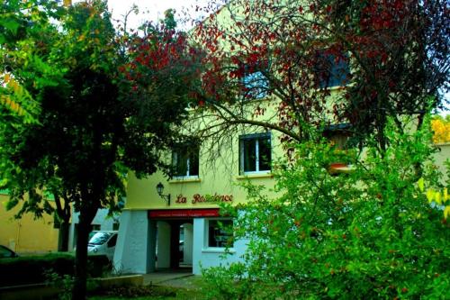 un bâtiment jaune avec des arbres devant lui dans l'établissement La Résidence - n° 06 - T2 classé**, à Gréoux-les-Bains