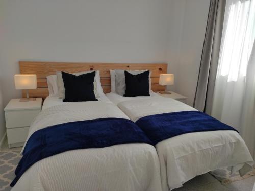 a large bed with blue and white sheets and pillows at CRÁTER 2 in El Paso