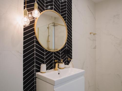 W łazience znajduje się biała umywalka i lustro. w obiekcie Apartament Nad Strumykiem z ogródkiem - Dream Apart w Ustroniu