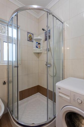 a shower in a bathroom with a washing machine at Sea view apartment in St Paul's Bay in St. Paul's Bay