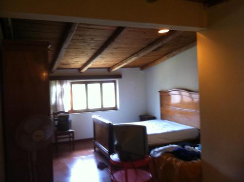 a bedroom with a bed and a television in it at CALABRIA COLLINA DI SCILLA CASALE OSTELLO1800 SELF SERVICE GIARDINO STANZE E APPARTAMENTI PER FAMIGLIE COPPIE E SINGLE Melia Pzza S Gaetano 16 in Castagnarella