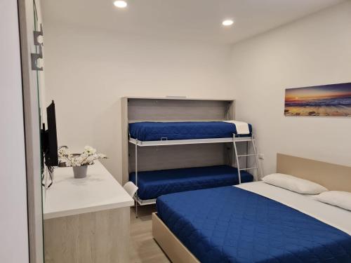 een slaapkamer met 2 stapelbedden met blauwe lakens bij B&B Rayl in Formia