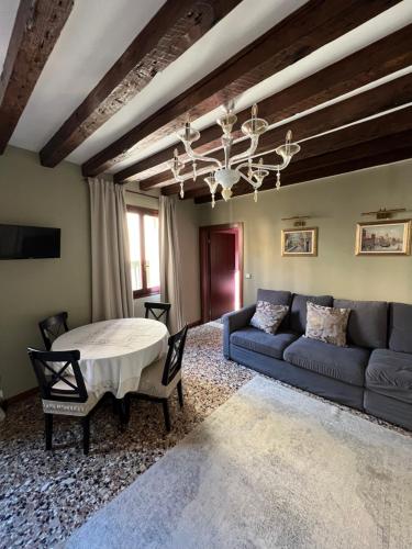- un salon avec un canapé bleu et une table dans l'établissement Wow suite 5 min from San Marco, à Venise
