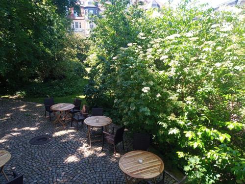 a group of tables and chairs next to a bush at Hotel Hollerbusch in Weimar
