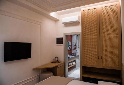 a room with a bed and a television on a wall at Elite Bay Hotel Lalez Durres in Lalëz
