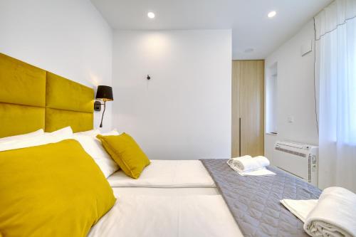 a bedroom with a large white bed with yellow pillows at Sidra city apartment in Zadar