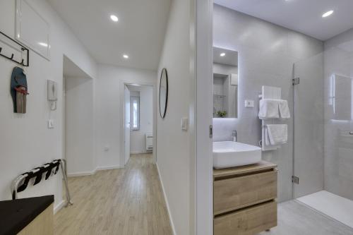 een witte badkamer met een wastafel en een spiegel bij Sidra city apartment in Zadar